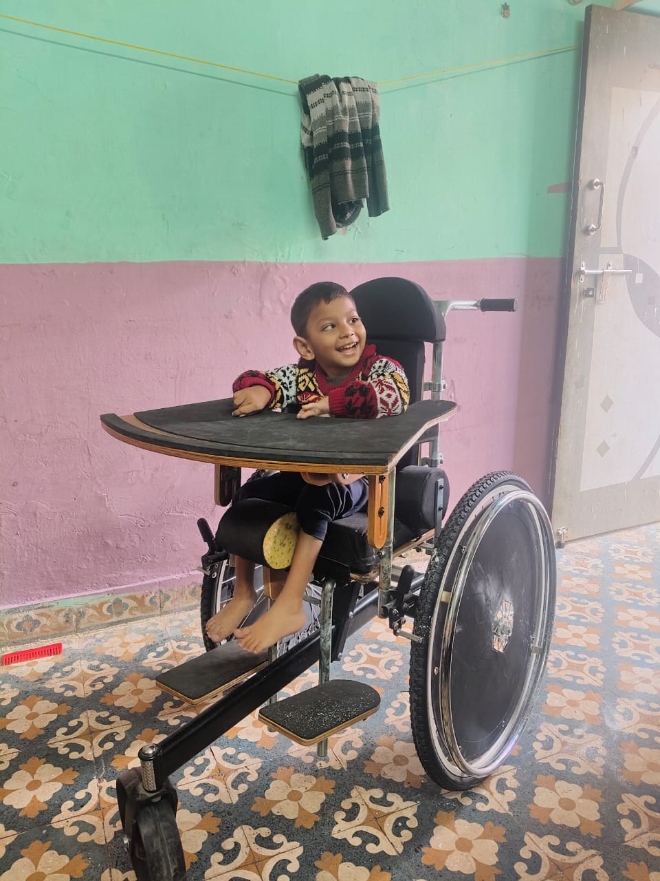 Child in adaprive wheelchair at Armaan day care